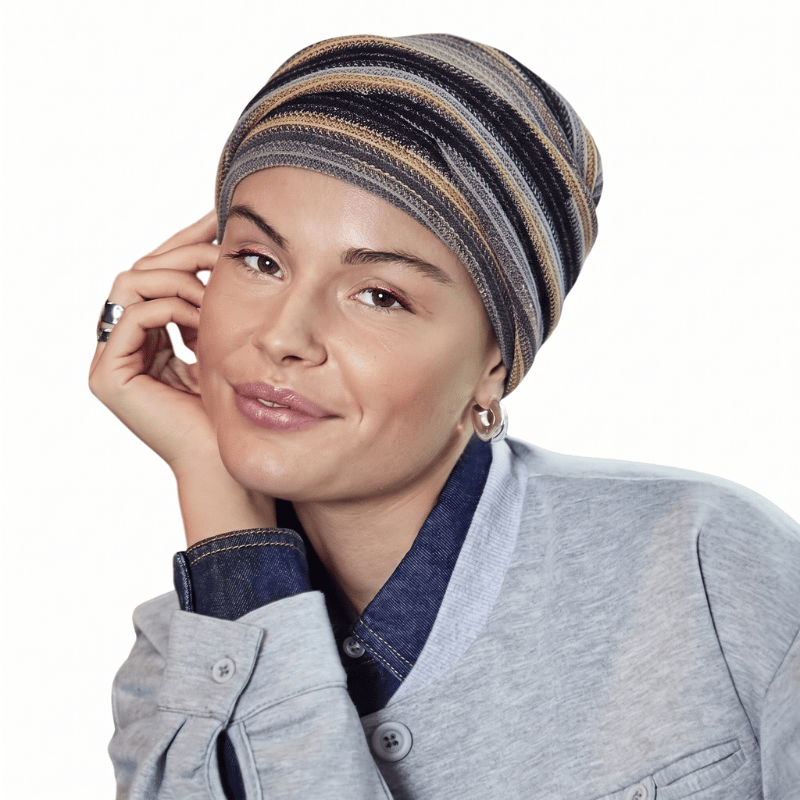 Mujer sonriente con turbante Zoya Black Autumn Stripes y pliegues suaves, vista frontal