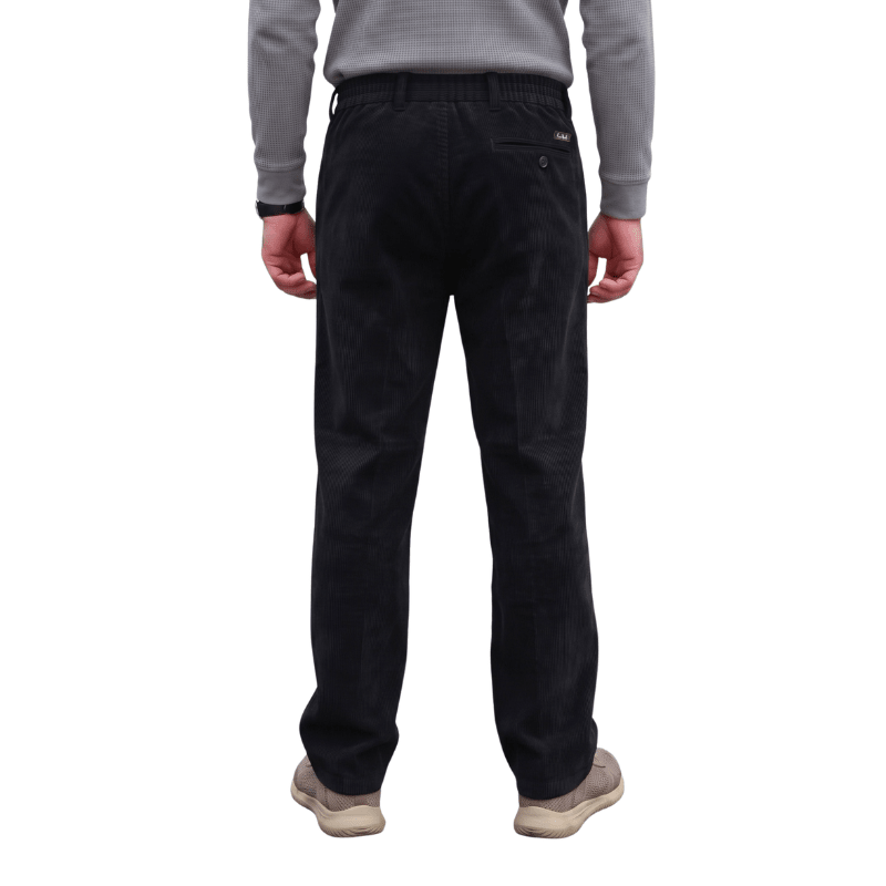 Vistos por detrás, pantalones de pana negros con cintura elástica, trabillas y un discreto bolsillo trasero
