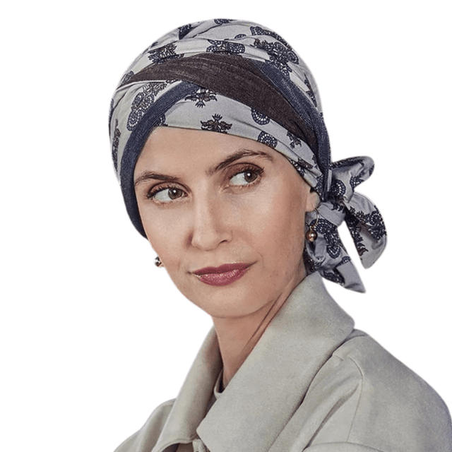 Mujer con turbante Beatrice de estampado paisley en tonos beige, marrón y azul, atado a un lado