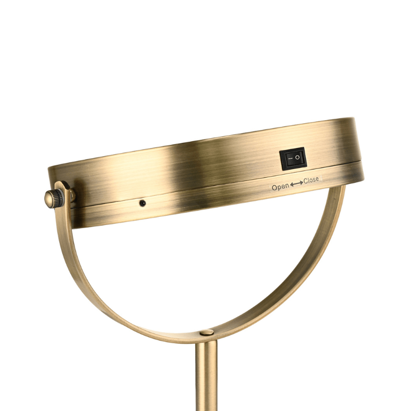Parte trasera del espejo de maquillaje dorado con luz, mostrando claramente el interruptor
