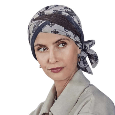 Mujer con turbante Beatrice de estampado paisley en tonos beige, marrón y azul, atado a un lado
