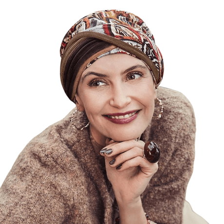 Mujer sonriente con turbante Shakti Tribal Feathers estampado de plumas en tonos otoñales