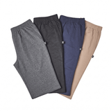 Cuatro pantalones de chándal en gris, negro, azul y beige, vistos desde arriba con cintura elástica y bolsillos laterales