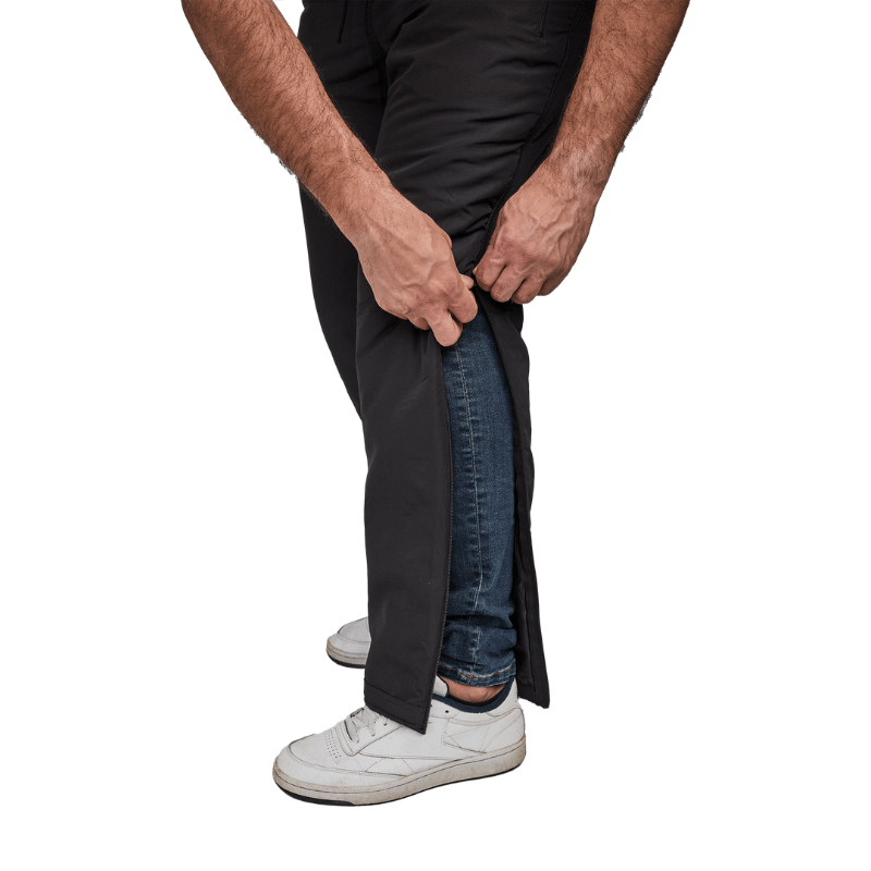 Primer plano de manos desabrochando pantalones térmicos Dobsom por el lado sobre vaqueros
