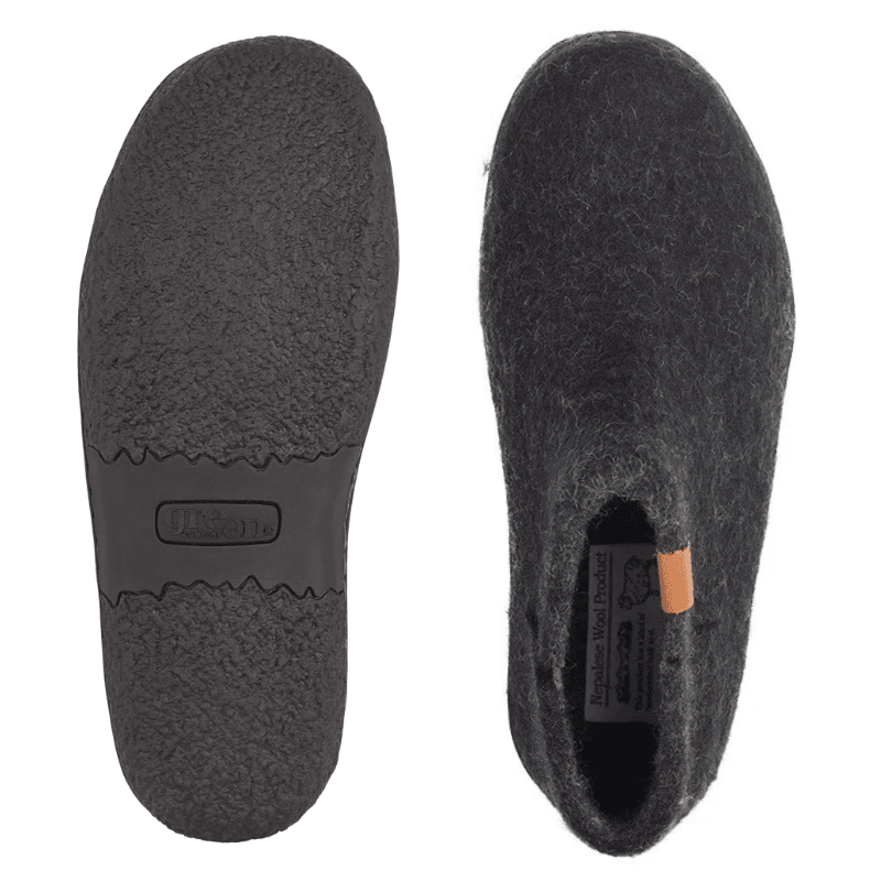 Dos zapatillas Green Comfort negras de fieltro de lana, una muestra la suela de goma antideslizante, la otra la parte superior
