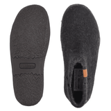 Dos zapatillas Green Comfort negras de fieltro de lana, una muestra la suela de goma antideslizante, la otra la parte superior