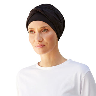 Turbante Shakti negro de viscosa de bambú en mujer, con elegante detalle cruzado frontal